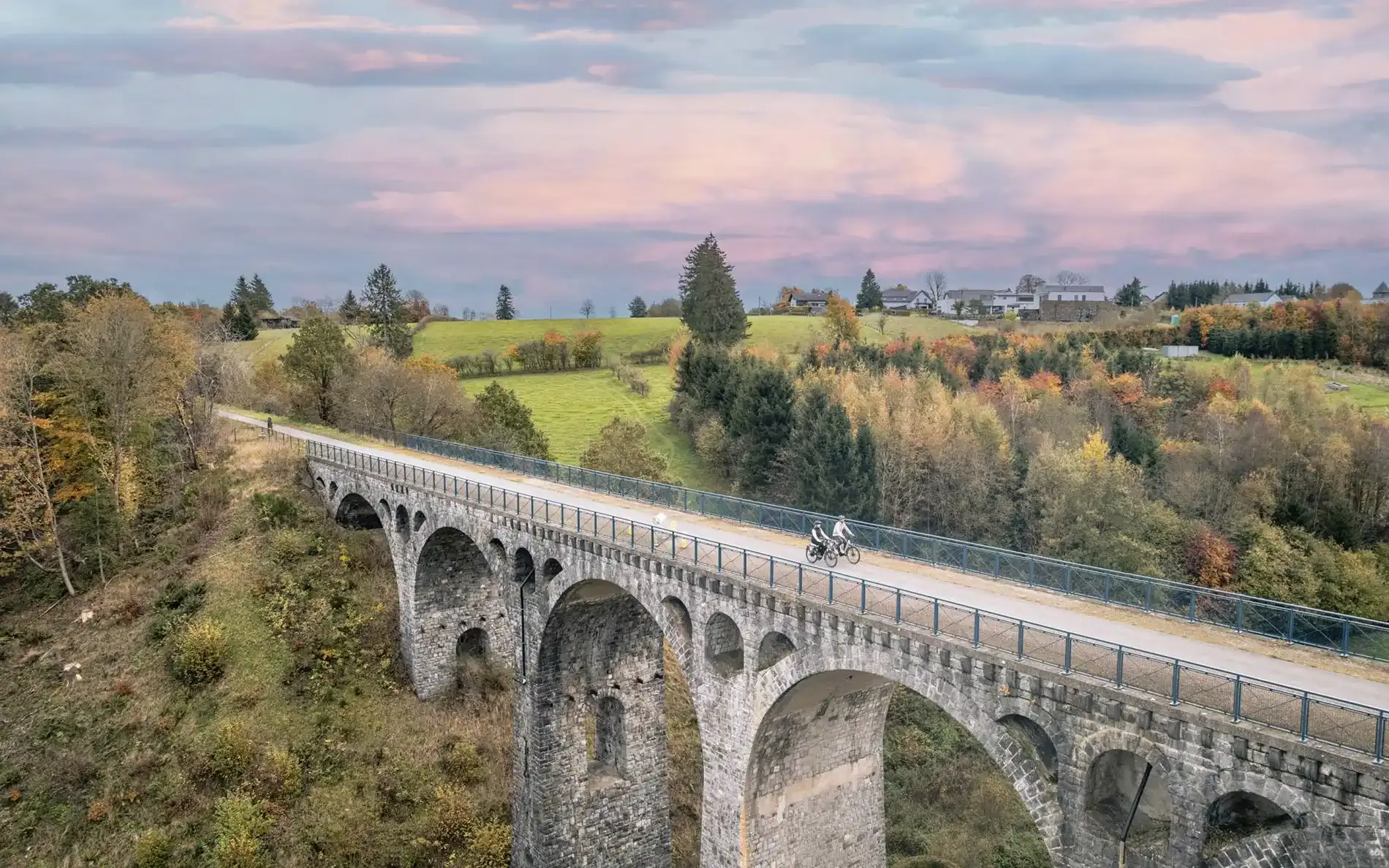 Zwei Radfahrer auf einem Viadukt der alten Bahntrasse, heute RAVeL-Radweg