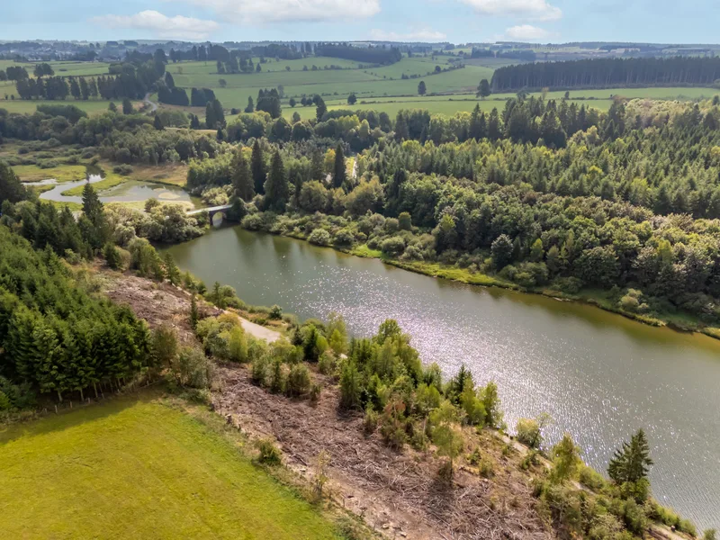 Luchtfoto van het glooiende heuvellandschap bij het meer van Bütgenbach, weiden en bossen rond het water