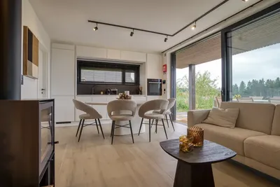 Cuisine ouverte, coin repas et canapé, grandes baies vitrées sur la terrasse