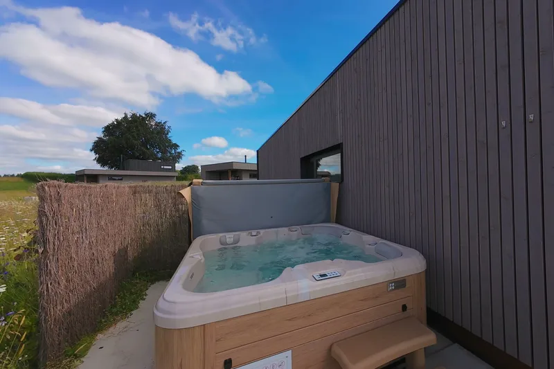 Sprudelnder Außen-Jacuzzi auf der Holzterrasse vor der Blumenwiese
