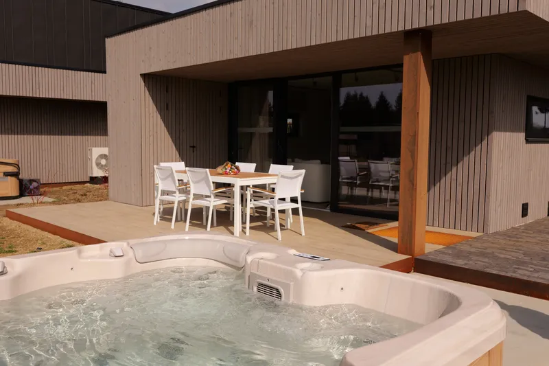 Privéjacuzzi onder de luifel van het terras, met de eettafel erachter
