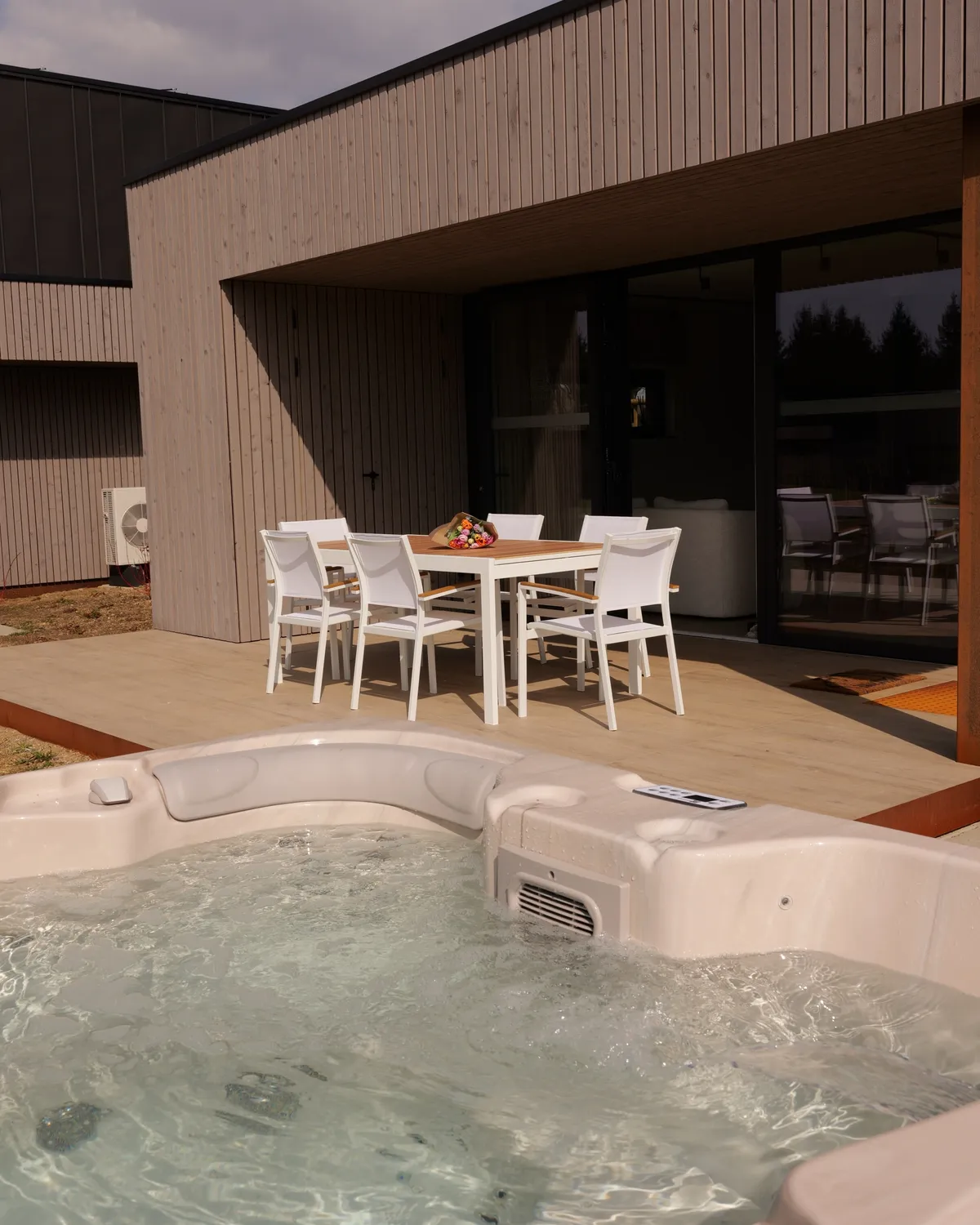 Covered terrace with dining table and jacuzzi, view over the meadow, 3-bedroom villa