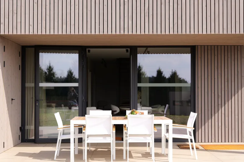 Eettafel op het terras, open glaswand naar de leefruimte